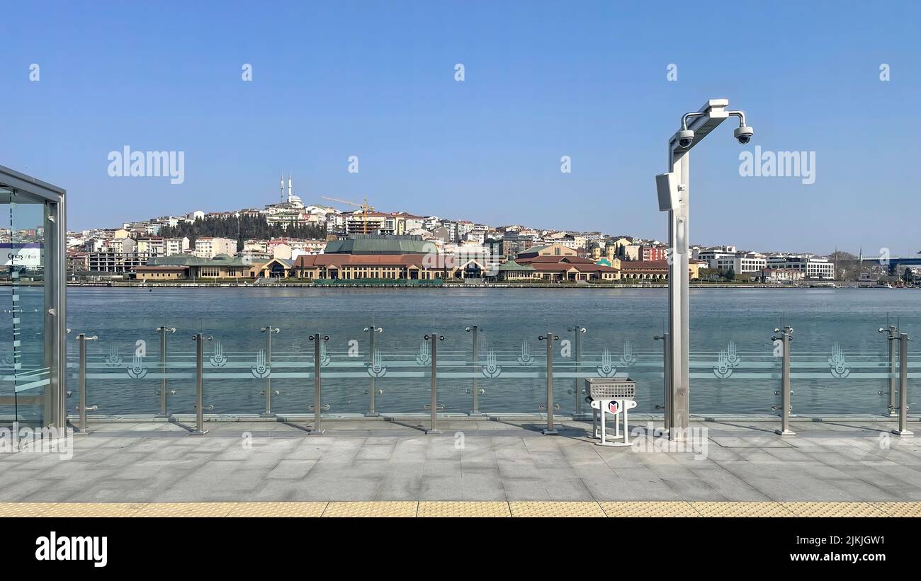 Un bellissimo scatto da un tram a una recinzione di metallo sulla riva del Corno d'Oro a Istanbul, Turchia, con un cielo blu Foto Stock