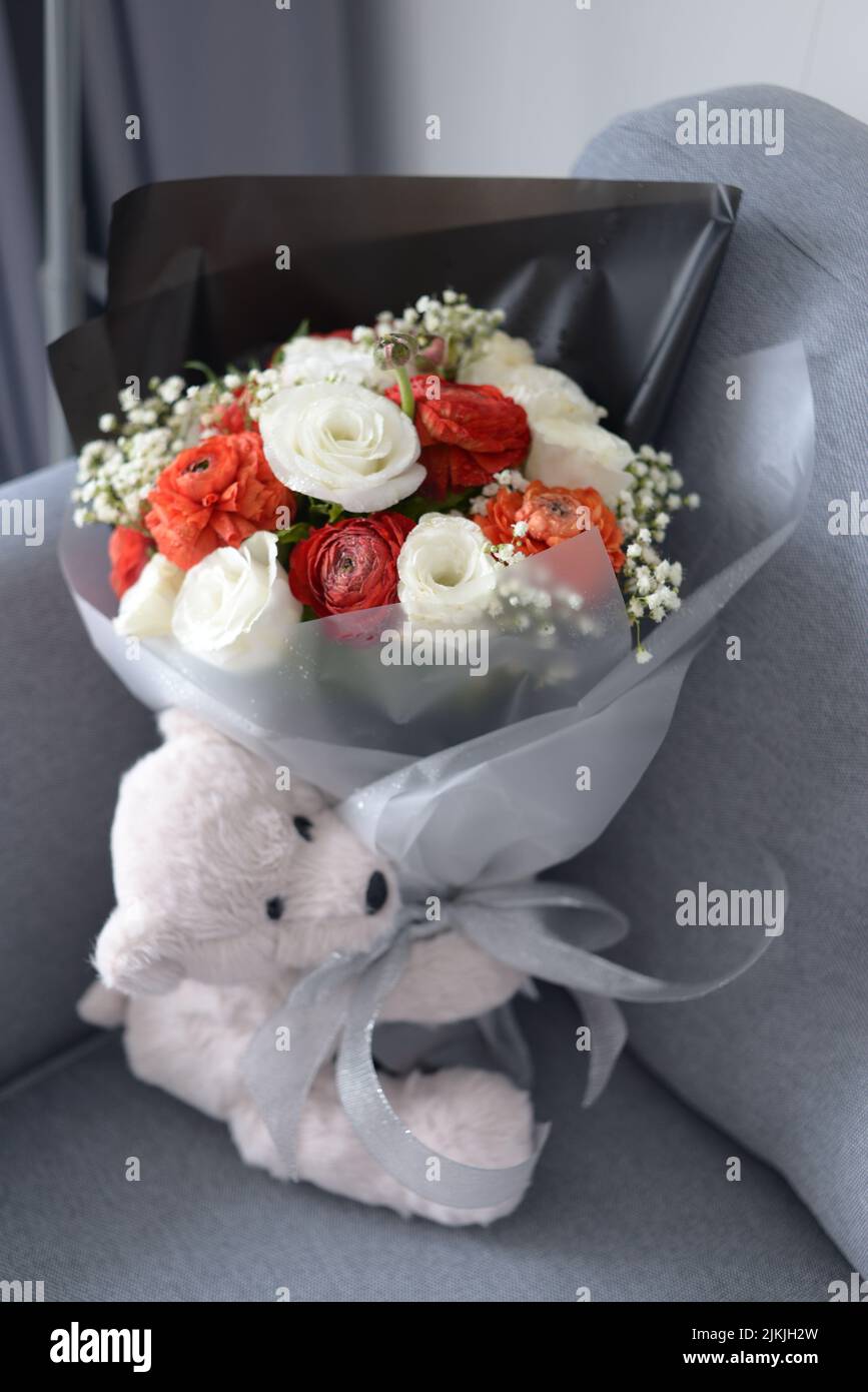 Un grazioso orsacchiotto e un bouquet di fiori Foto Stock