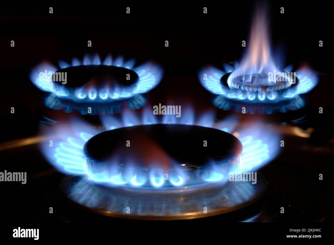 Fiamme di gas che bruciano su una stufa con fiamma blu Foto Stock