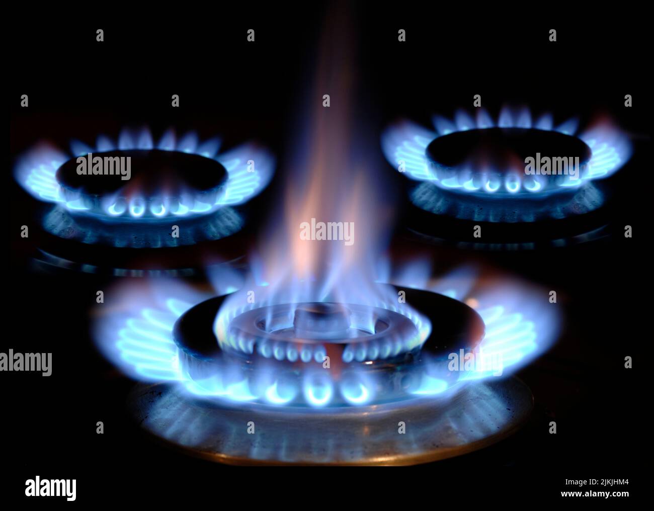 Fiamme di gas che bruciano su una stufa con fiamma blu Foto Stock