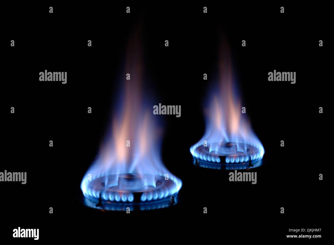 Fiamme di gas che bruciano su una stufa con fiamma blu Foto Stock