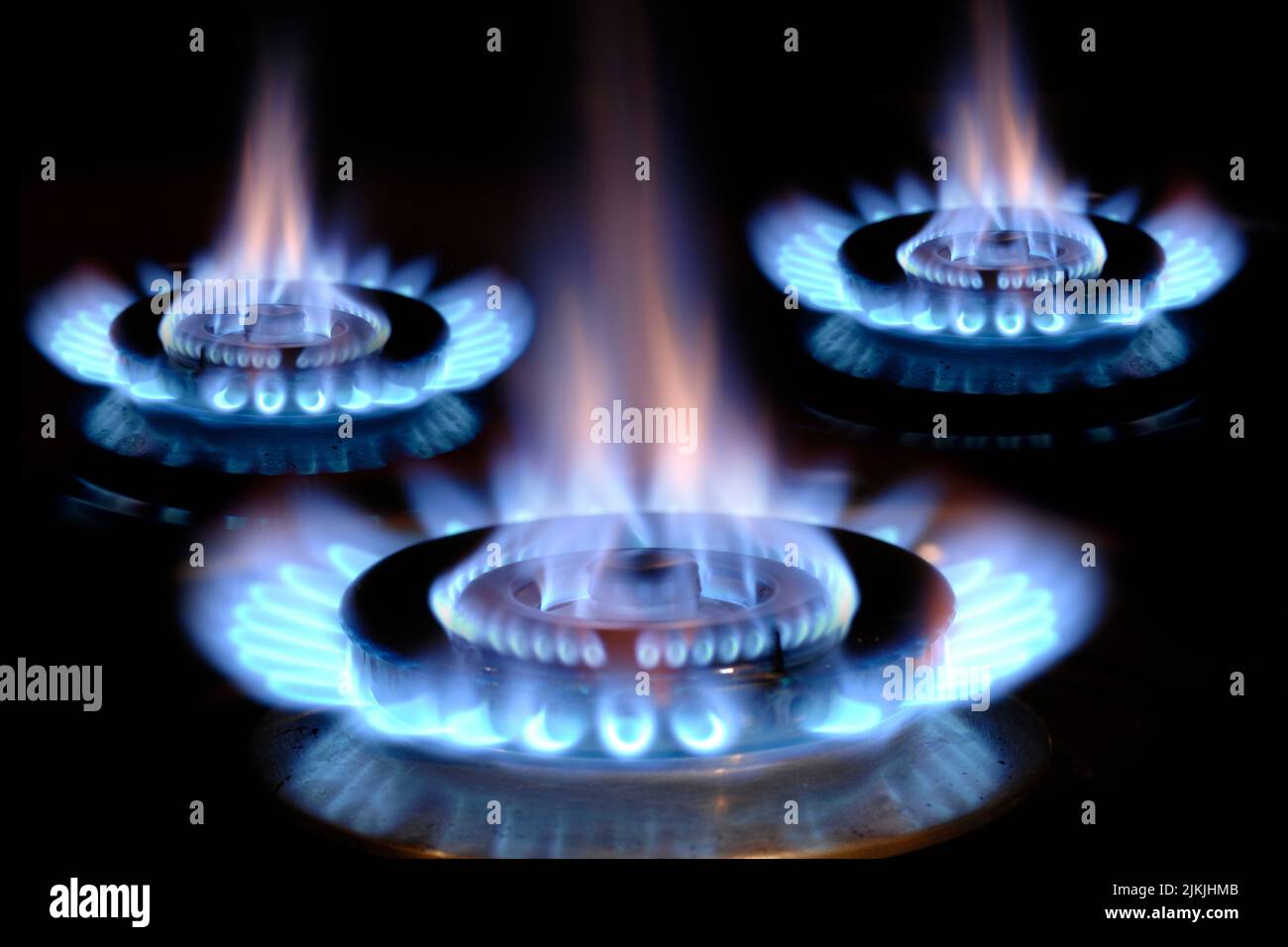 Fiamme di gas che bruciano su una stufa con fiamma blu Foto Stock