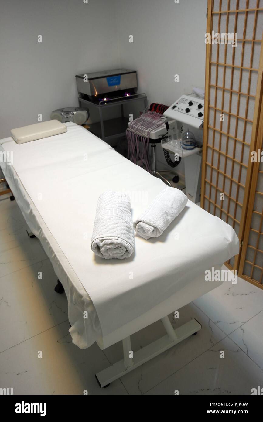 Uno scatto verticale dell'interno della sala massaggi, tavolo da massaggio nella spa, trattamento della pelle. Foto Stock