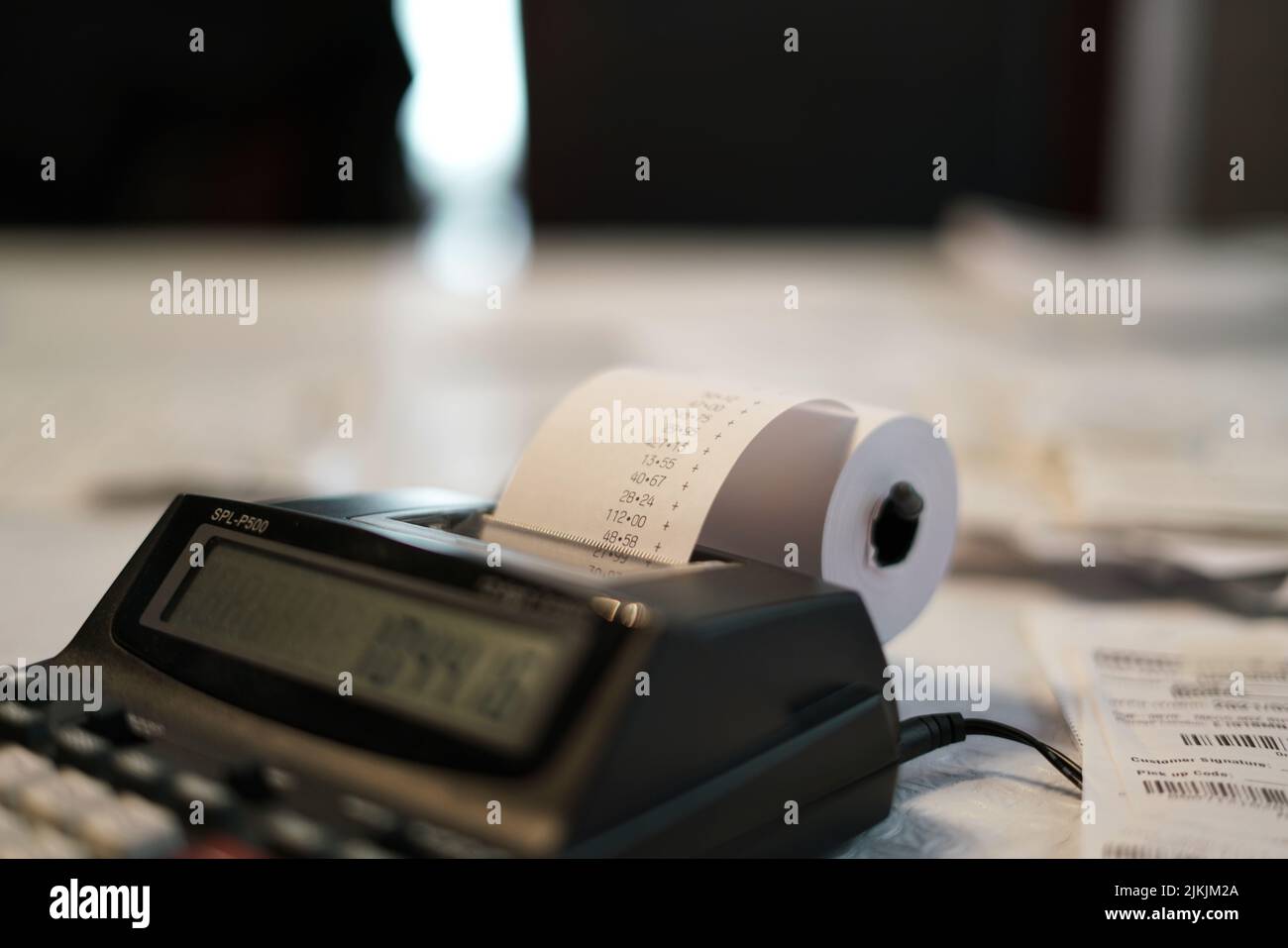 Primo piano di una calcolatrice a stampa con carta stampata con rotolo che completa le tasse annuali Foto Stock