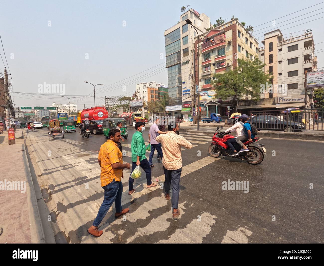 Un bellissimo scatto di persone che attraversano la strada e persone in bicicletta a Dhaka City, Bangladesh Foto Stock