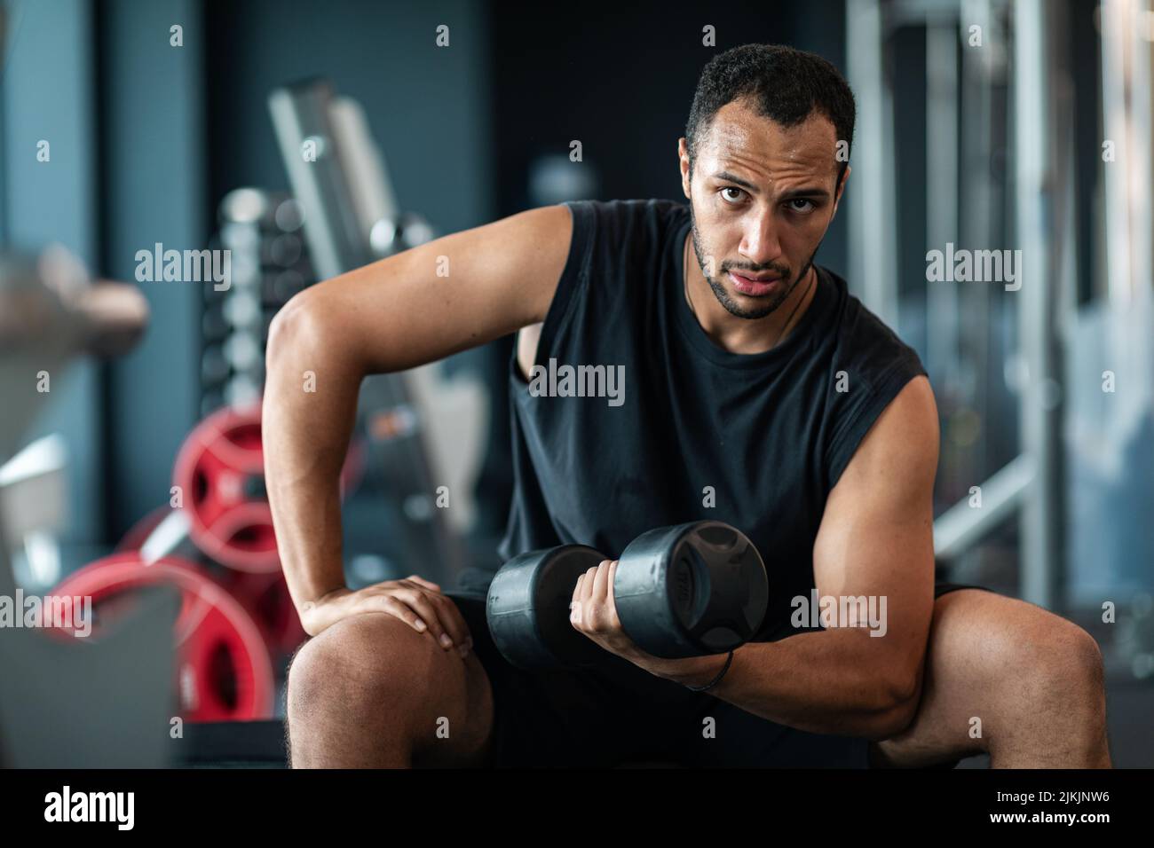 Ritratto di atleta maschile afroamericana con Dumbbell in palestra Foto Stock