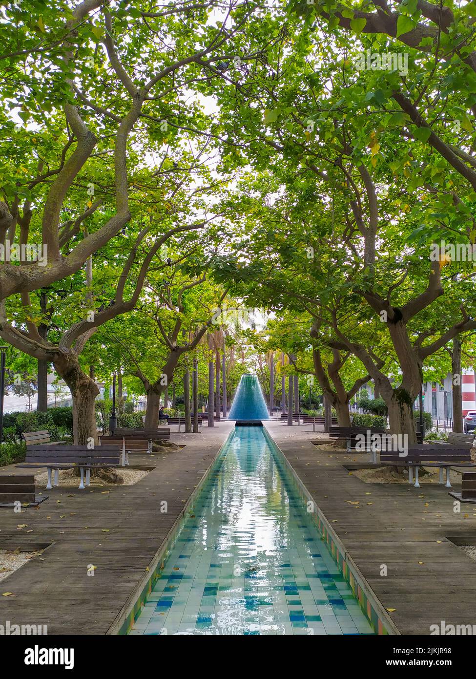 Uno scatto verticale di una lunga piscina fontana nel parco. Foto Stock