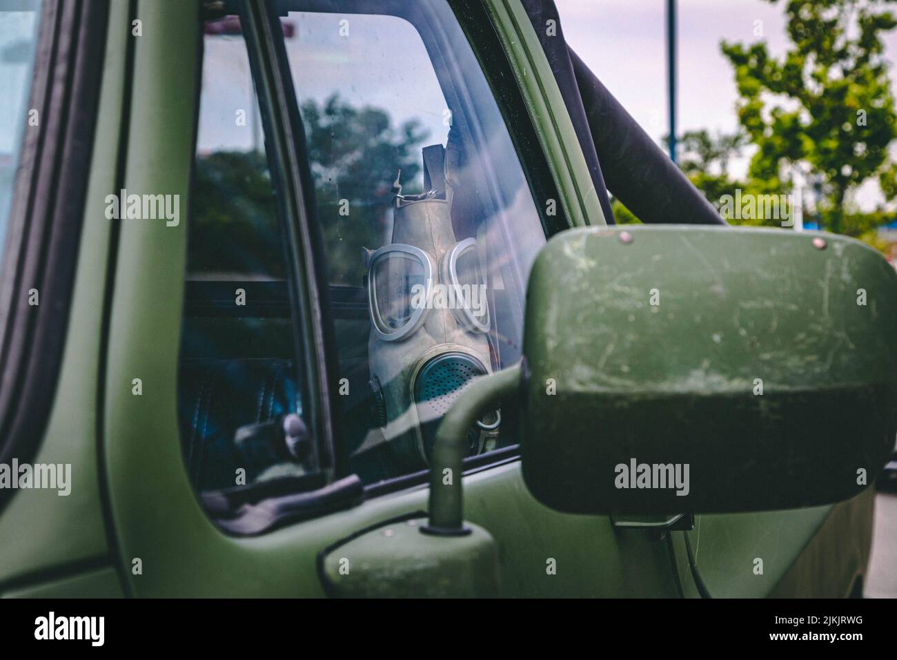 Una maschera a gas appesa all'interno del camion verde Foto Stock