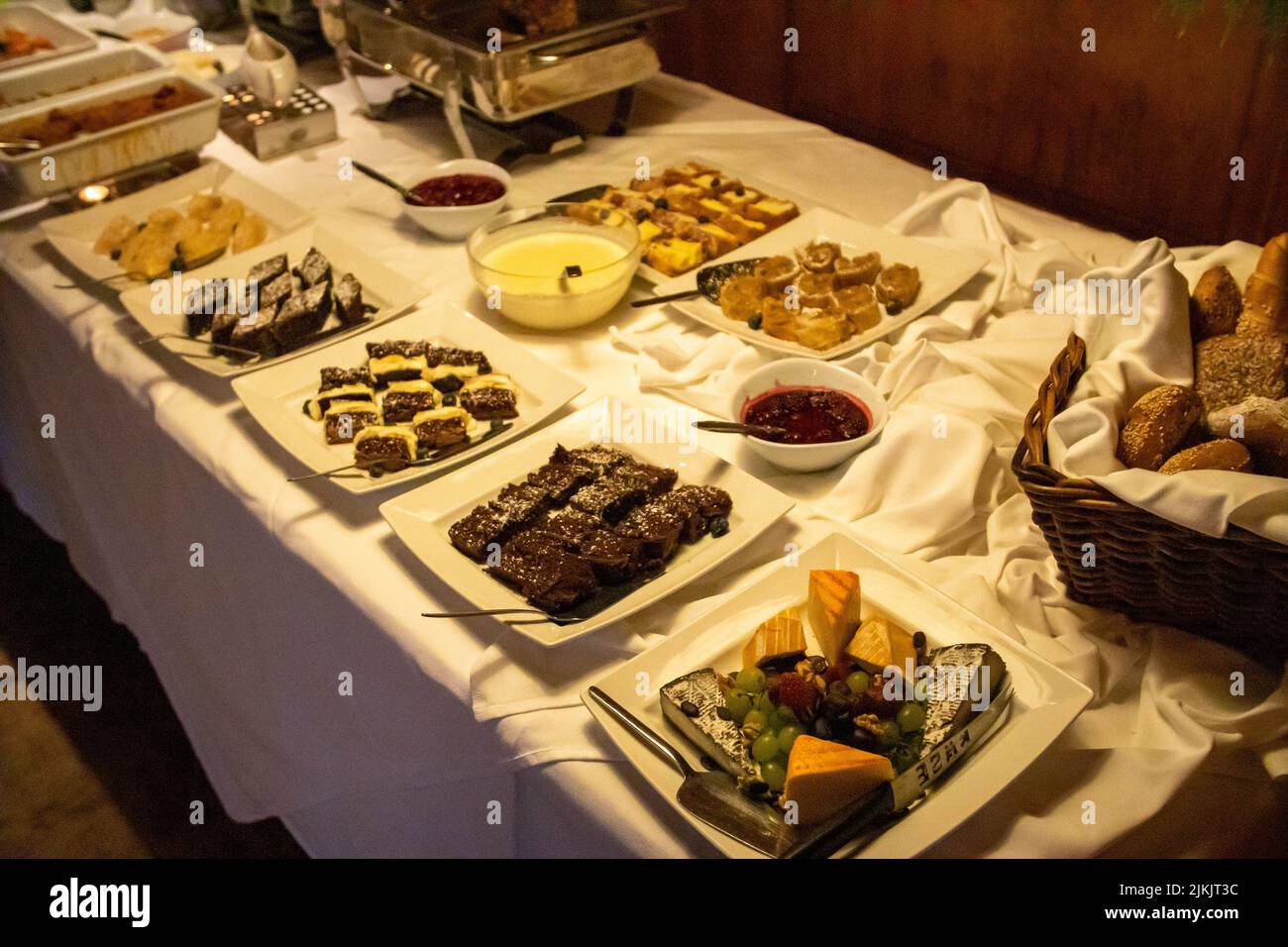 Un primo piano di piatti con gustosi dessert al tavolo da pranzo a buffet Foto Stock