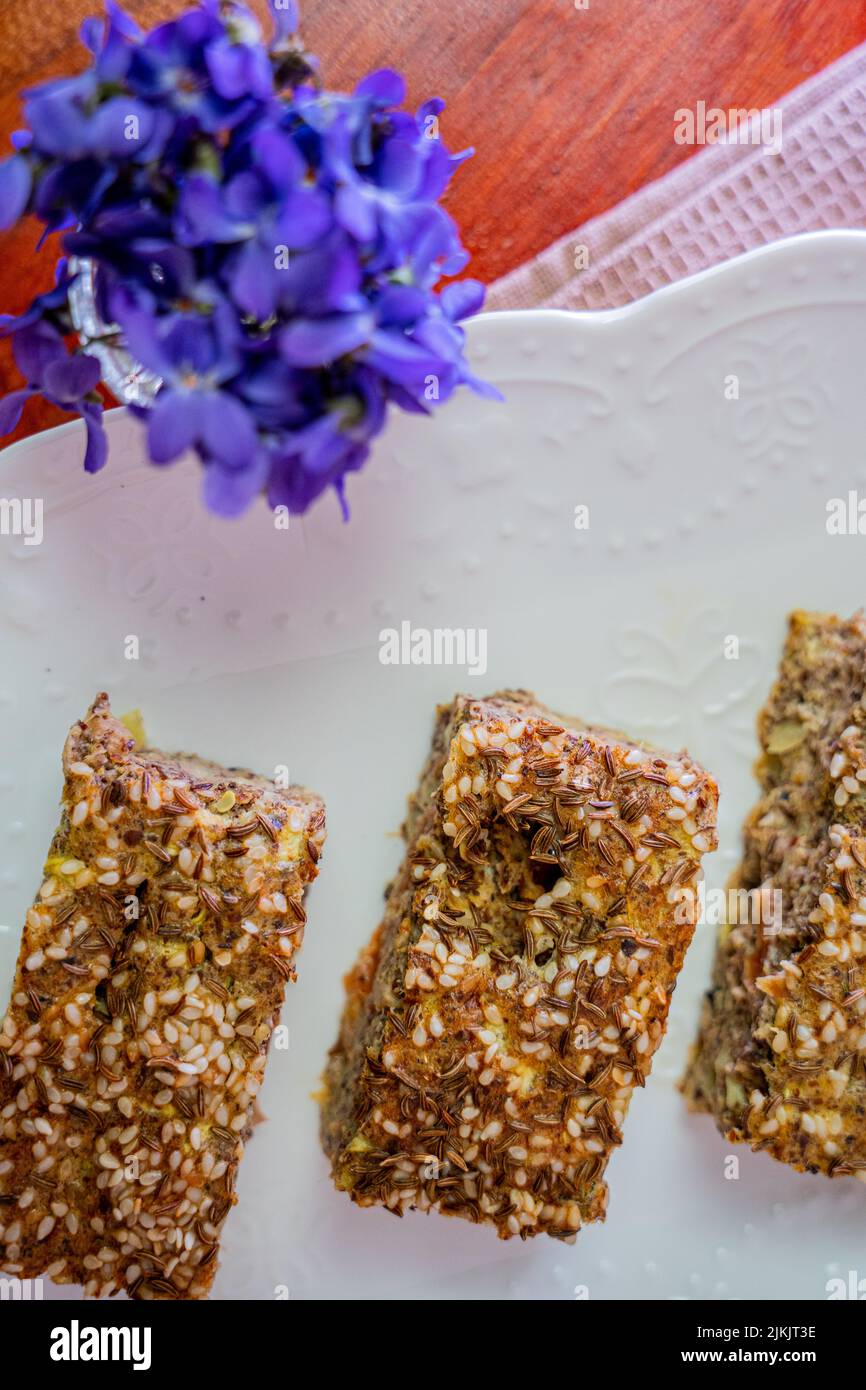 Una vista dall'alto della torta di pane Flex Seed su un tavolo con una decorazione floreale Foto Stock