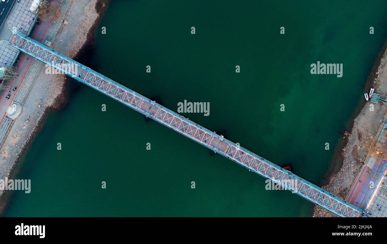 Una vista aerea di un ponte blu sullo stretto fiume verde Foto Stock