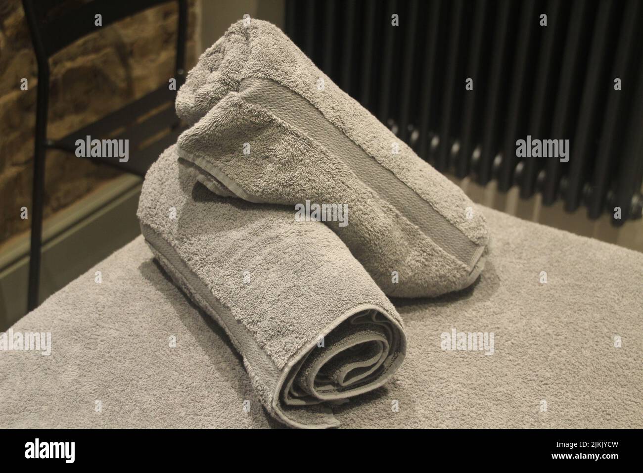 Due asciugamani grigi sul morbido letto in una sala massaggi Foto Stock