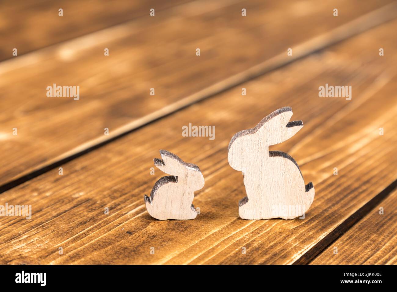 Un primo piano di due coniglietti di legno per Pasqua posti su un tavolo di legno Foto Stock
