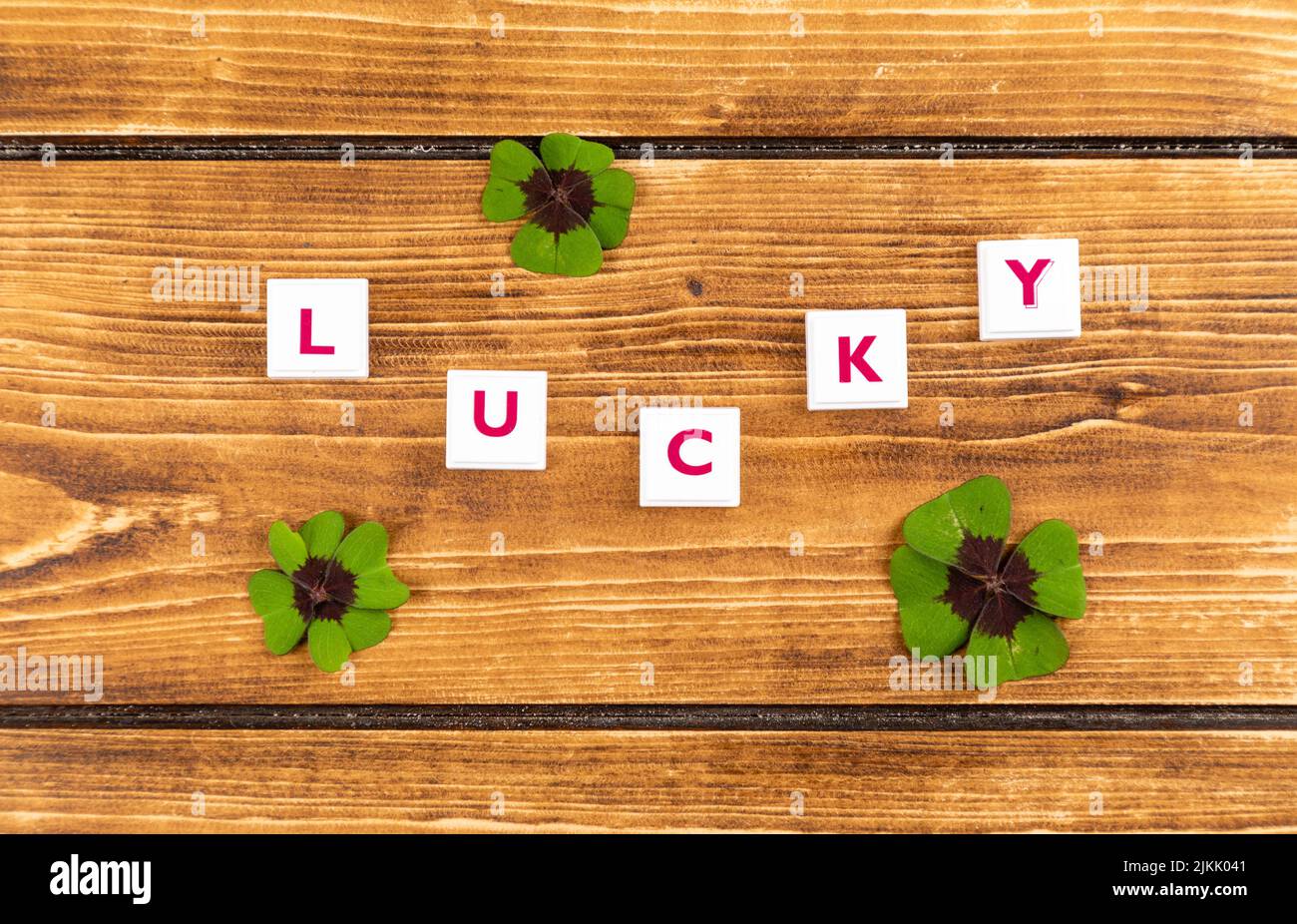 texte sur lucky on a ligned background with green lucky clover Foto Stock