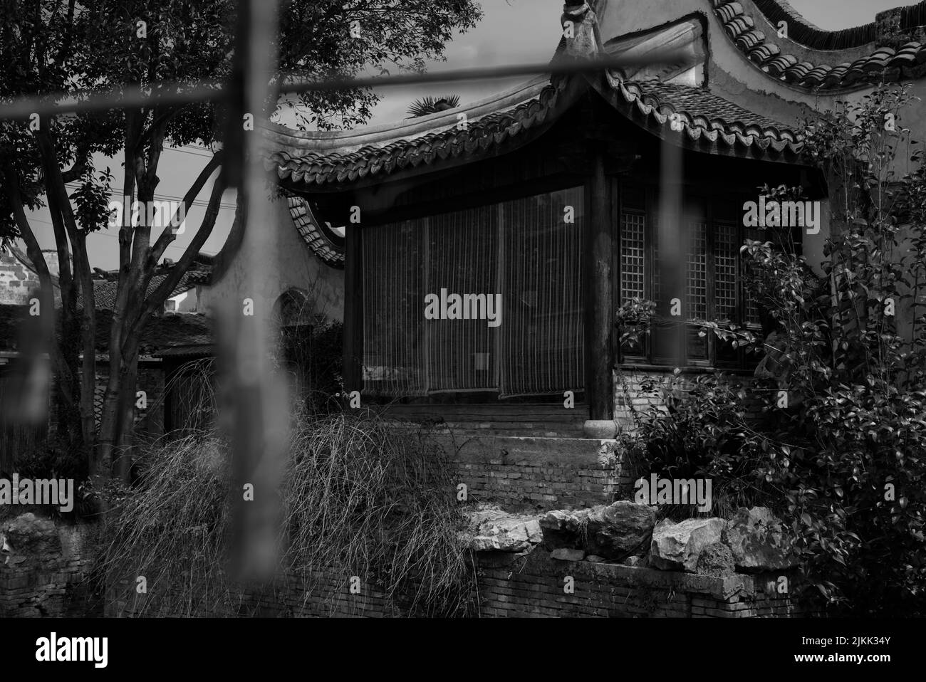 Una scala di grigi ripresa da dietro recinzione di vecchia casa nel vecchio villaggio, Shanghai, Cina Foto Stock
