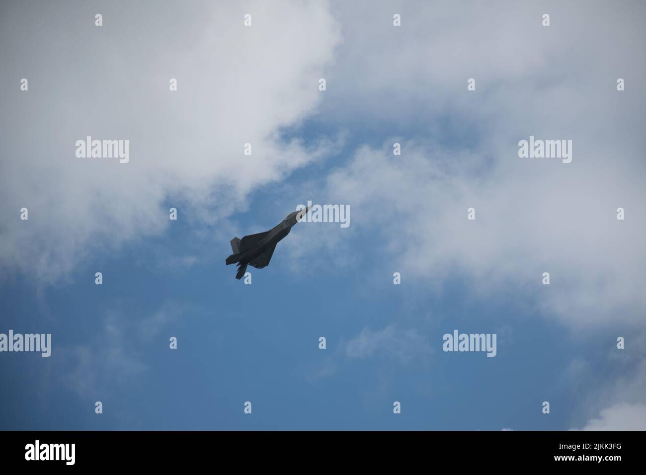 Un tiro a basso angolo di un velivolo furtivo Lockheed Martin F-22 Raptor che vola nel cielo Foto Stock