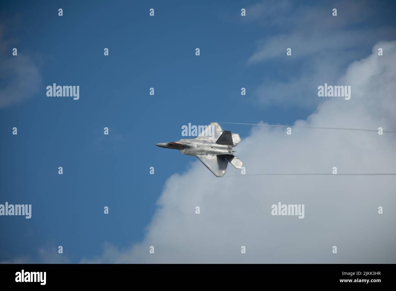 Un primo piano di un velivolo furtivo Lockheed Martin F-22 Raptor volare nel cielo con tracce Foto Stock