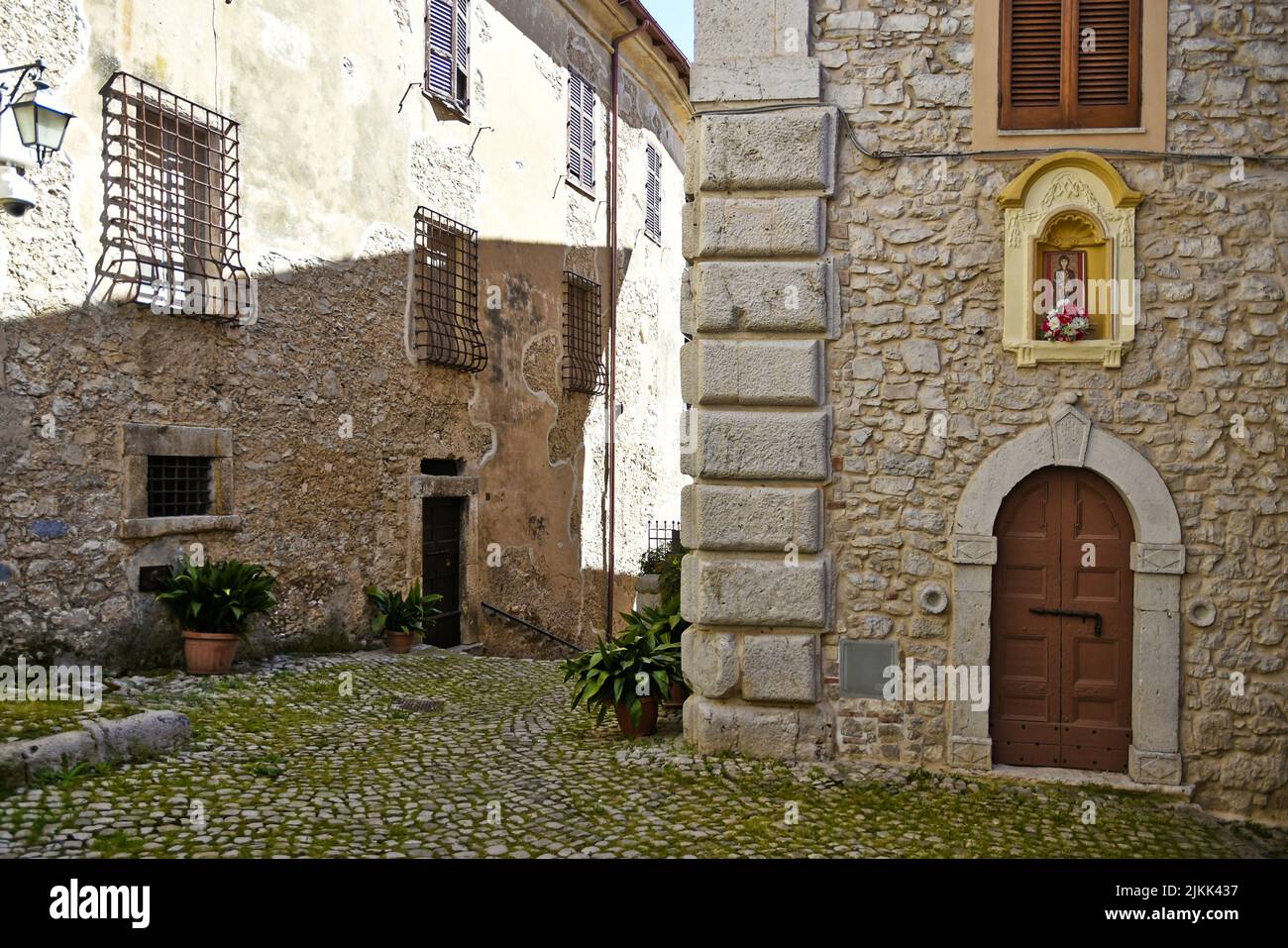 Una strada acciottolata tra vecchi edifici in pietra medievale di giorno. Foto Stock