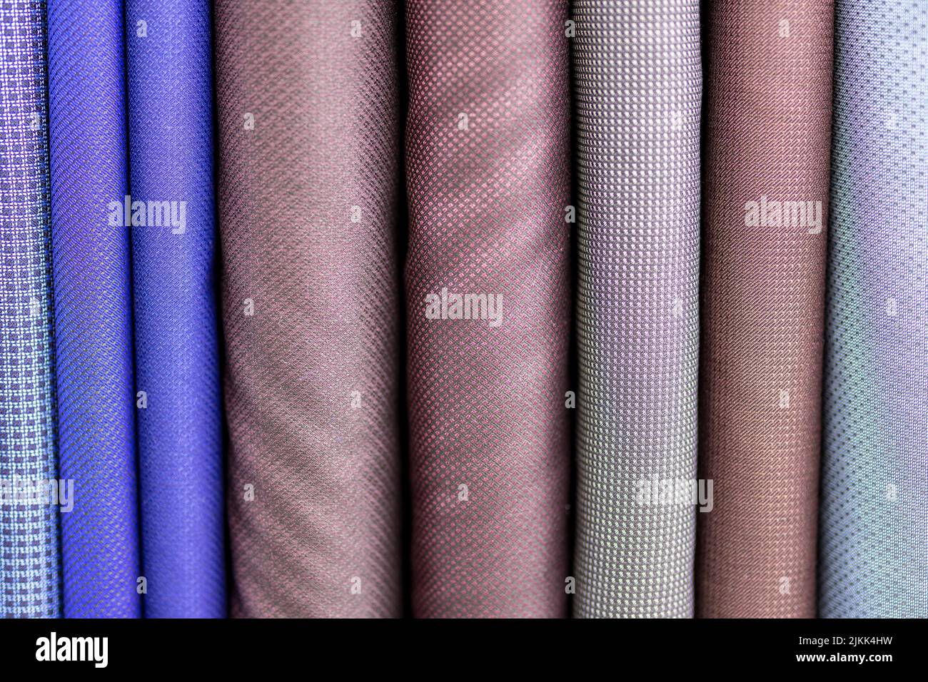 I bulloni viola, grigio e blu di tessuto per la realizzazione di abiti da un sarto Foto Stock