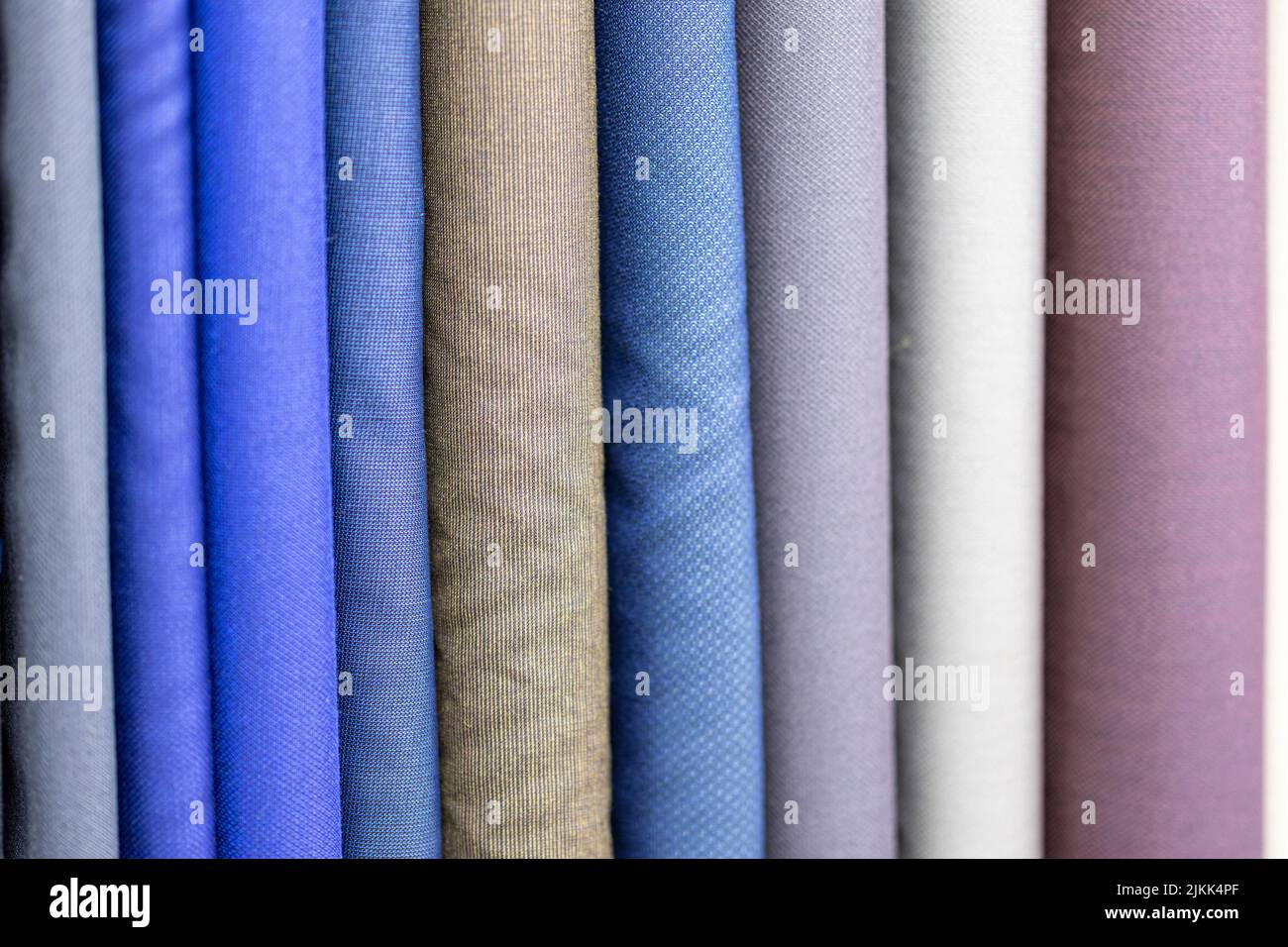 I bulloni di tessuto blu, marrone e grigio per la realizzazione di abiti da un sarto Foto Stock