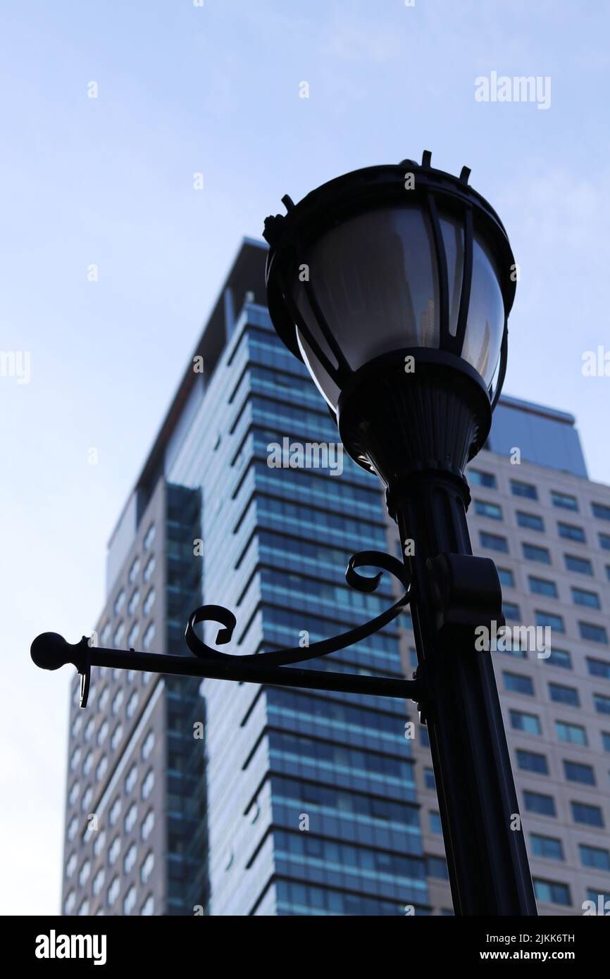 Un basso angolo di lampada da strada e un moderno edificio a più piani sullo sfondo Foto Stock