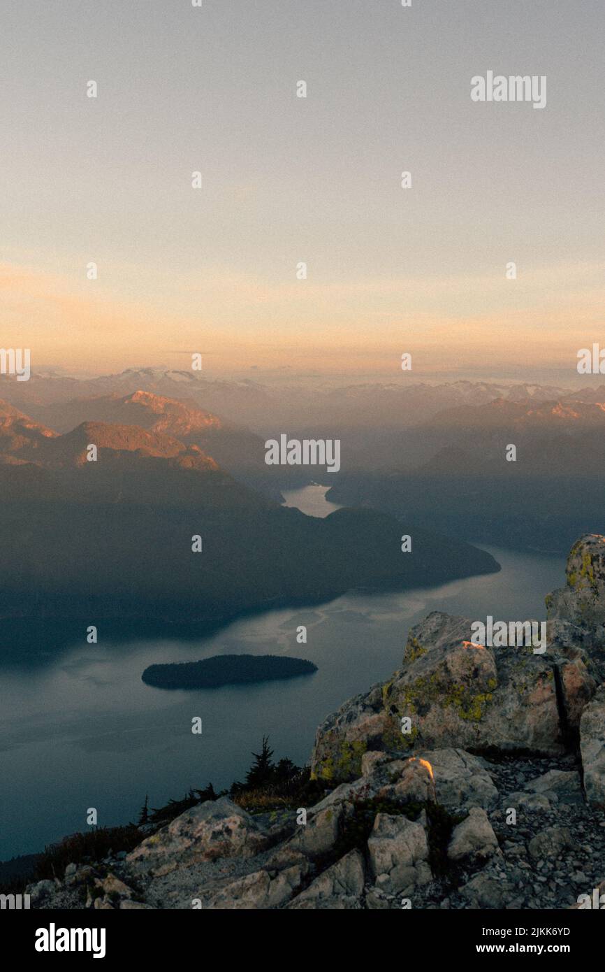 Un colpo panoramico di montagne lungo un fiume durante l'alba Foto Stock