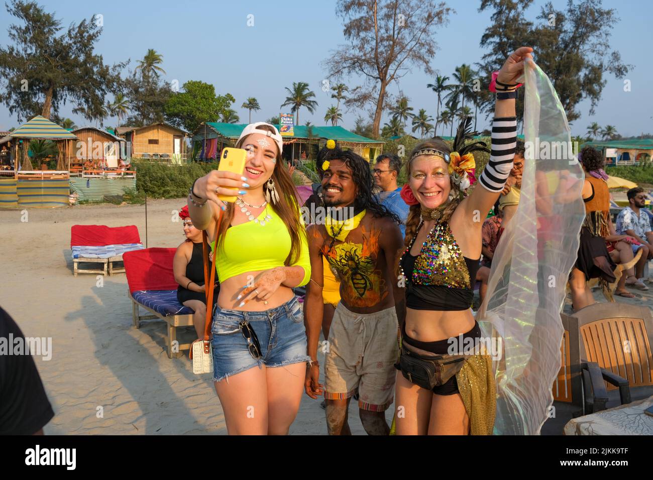 Alcune persone che prendono un selfie sulla spiaggia alla festa del carnevale. Foto Stock