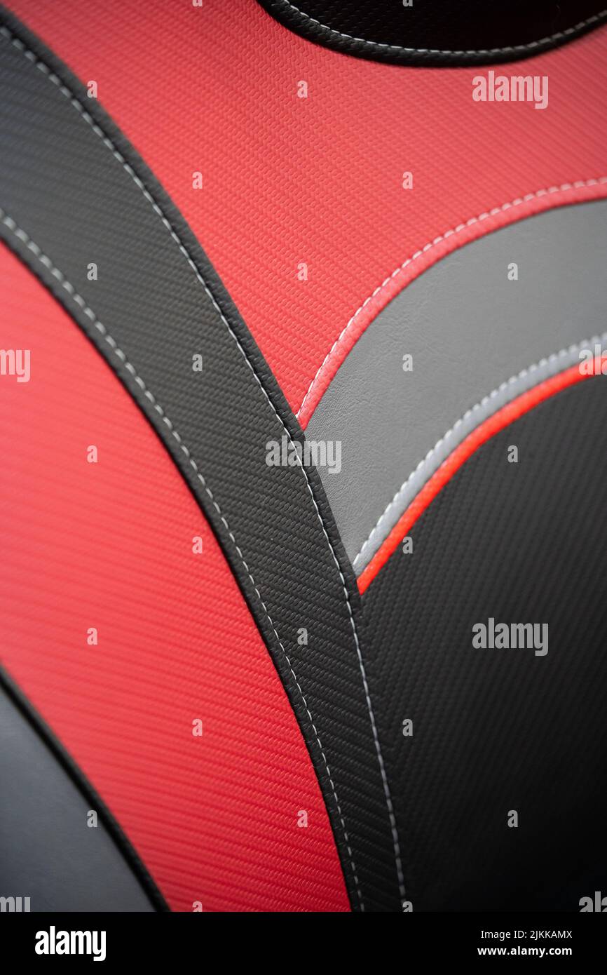 Moderna vettura sportiva con interni in pelle nera e rossa. Parte dei dettagli dei sedili in pelle con cuciture bianche. Foto Stock