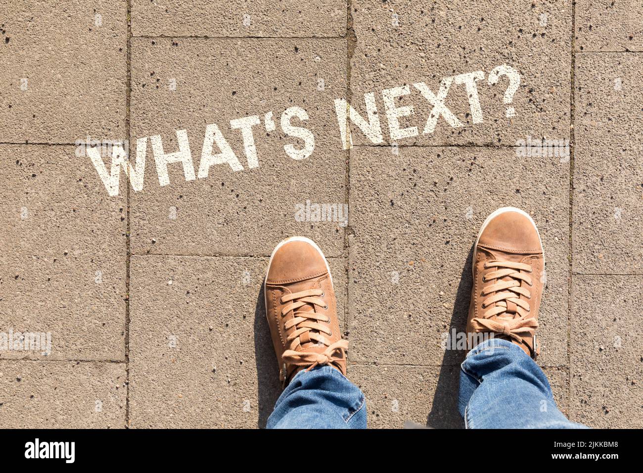 scarpe su asfalto con testo what's next? Foto Stock