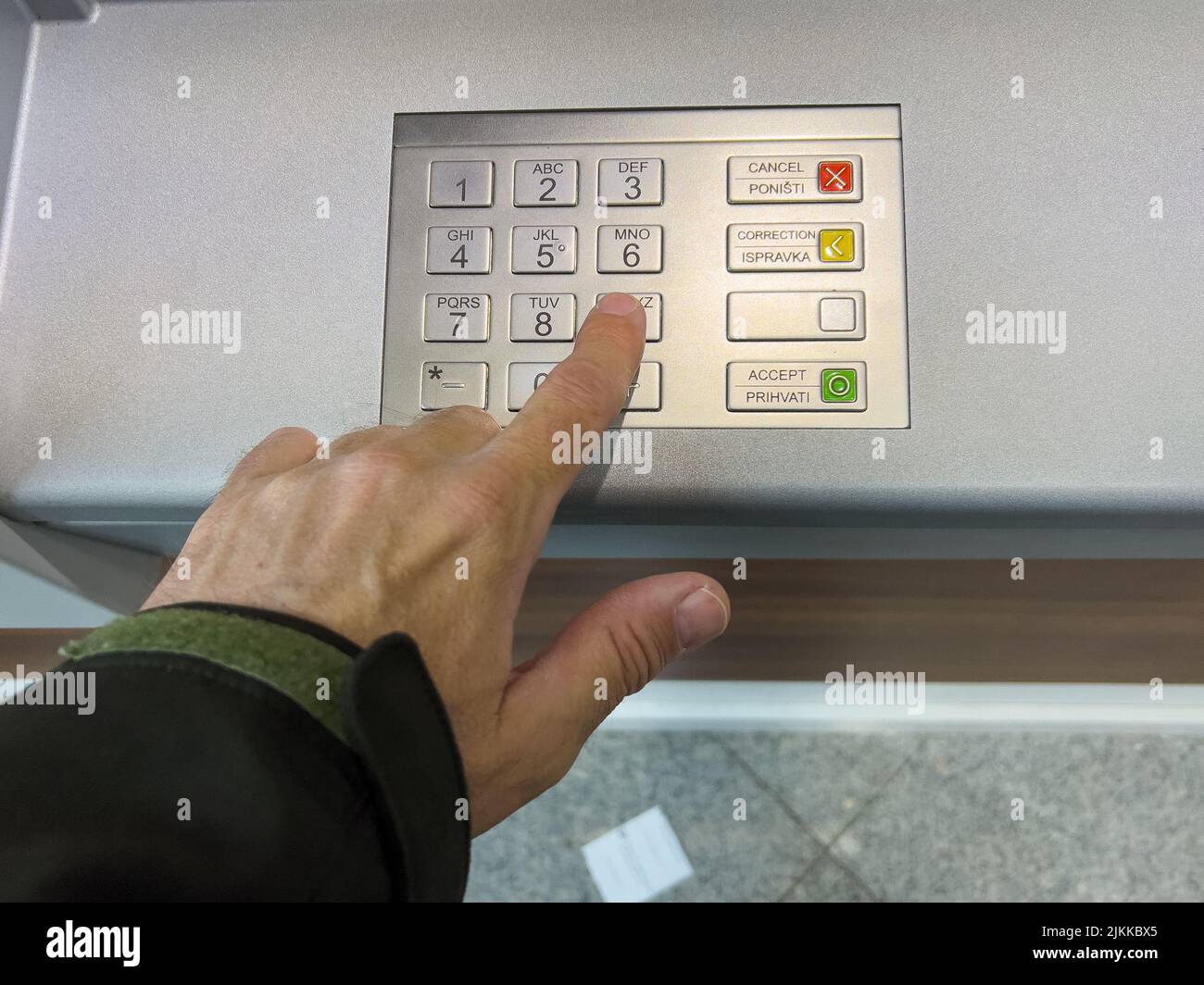 Immagine ravvicinata di un dito che preme i pulsanti di una macchina ATM. Foto Stock