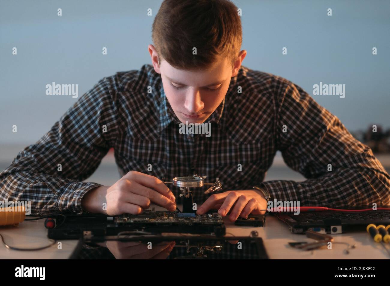 il tecnico addetto alla riparazione elettronica dismonta la scheda madre Foto Stock