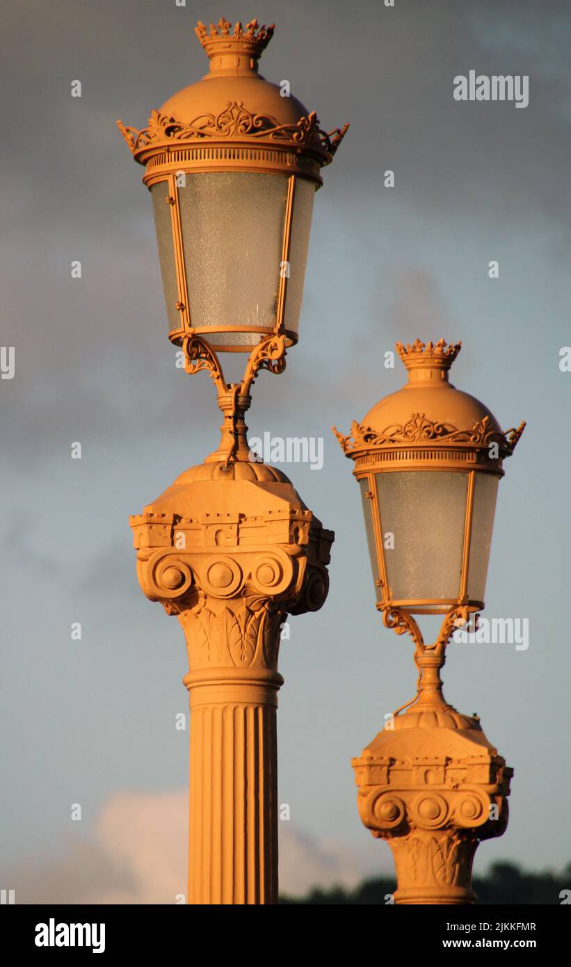 Una vista delle colonne con luci su una strada al tramonto Foto Stock