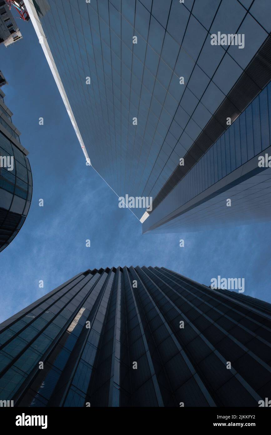 Un inquadramento a basso angolo di due grattacieli con cielo nuvoloso e scuro Foto Stock