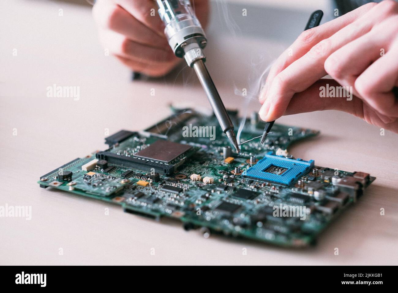 tecnico di riparazione elettronica per la saldatura della scheda madre Foto Stock