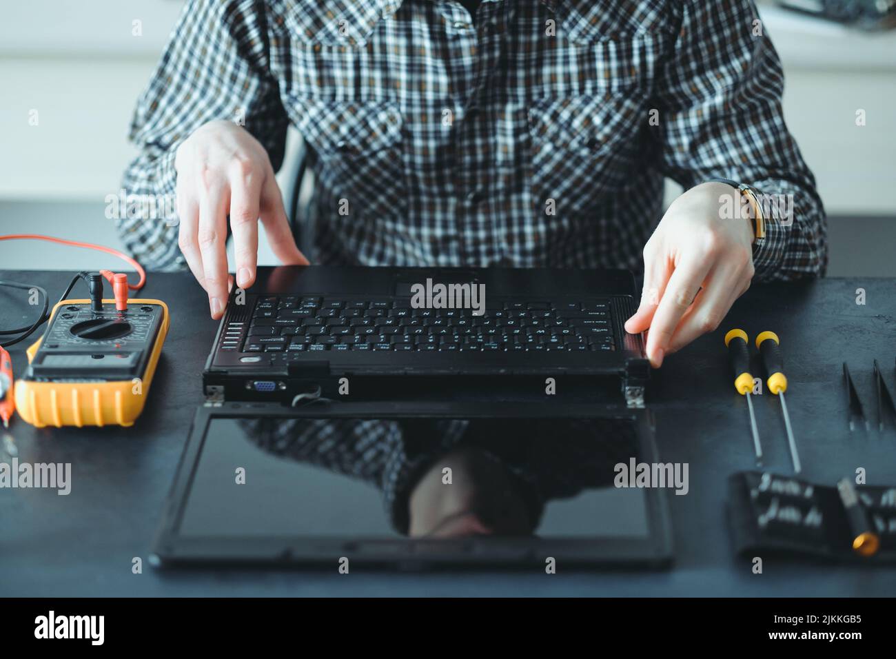 il tecnico addetto alla riparazione elettronica dismonta il computer portatile Foto Stock