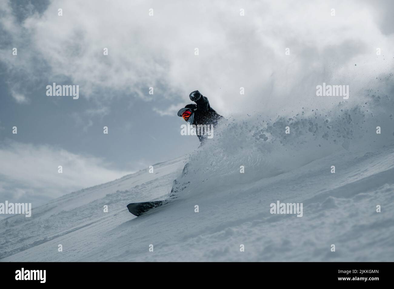 Uno snowboarder si sposta lungo la pista da sci Foto Stock