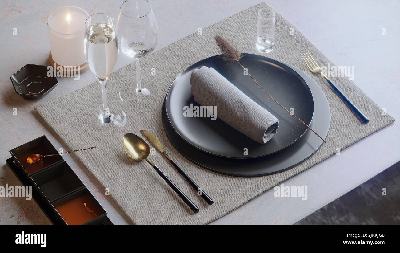 Un primo piano di piatti con coltello, cucchiaio, forchetta, candela e bicchieri di vetro su un tavolo Foto Stock