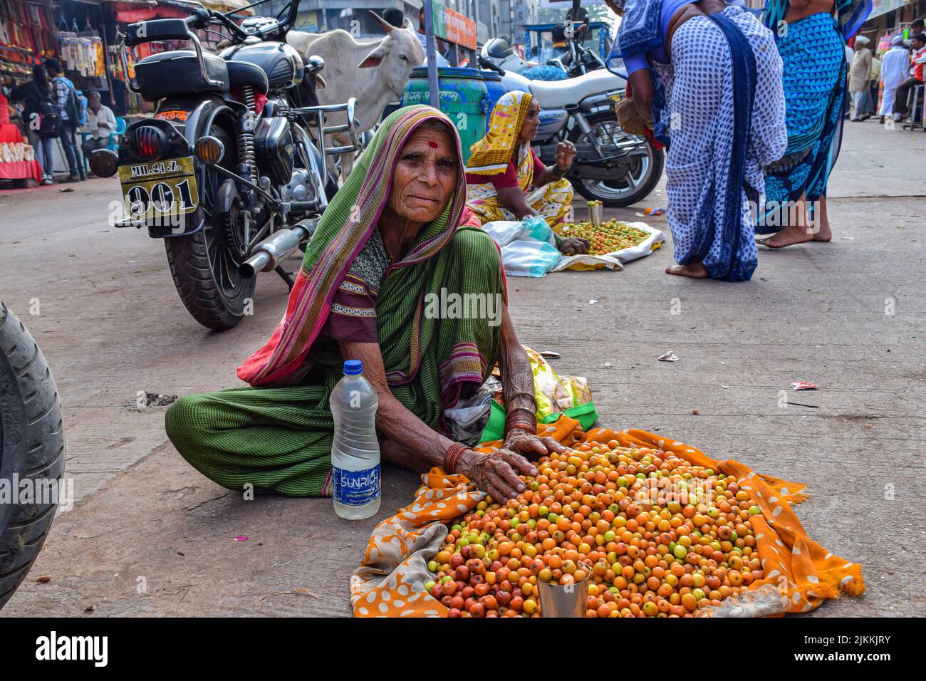 Tuljapur, India- Dicembre 19th 2019; Stock photo di 60 a 70 di età nonna indiana o donne anziane che indossano saree , vendendo frutta jujube sulla strada di ci Foto Stock