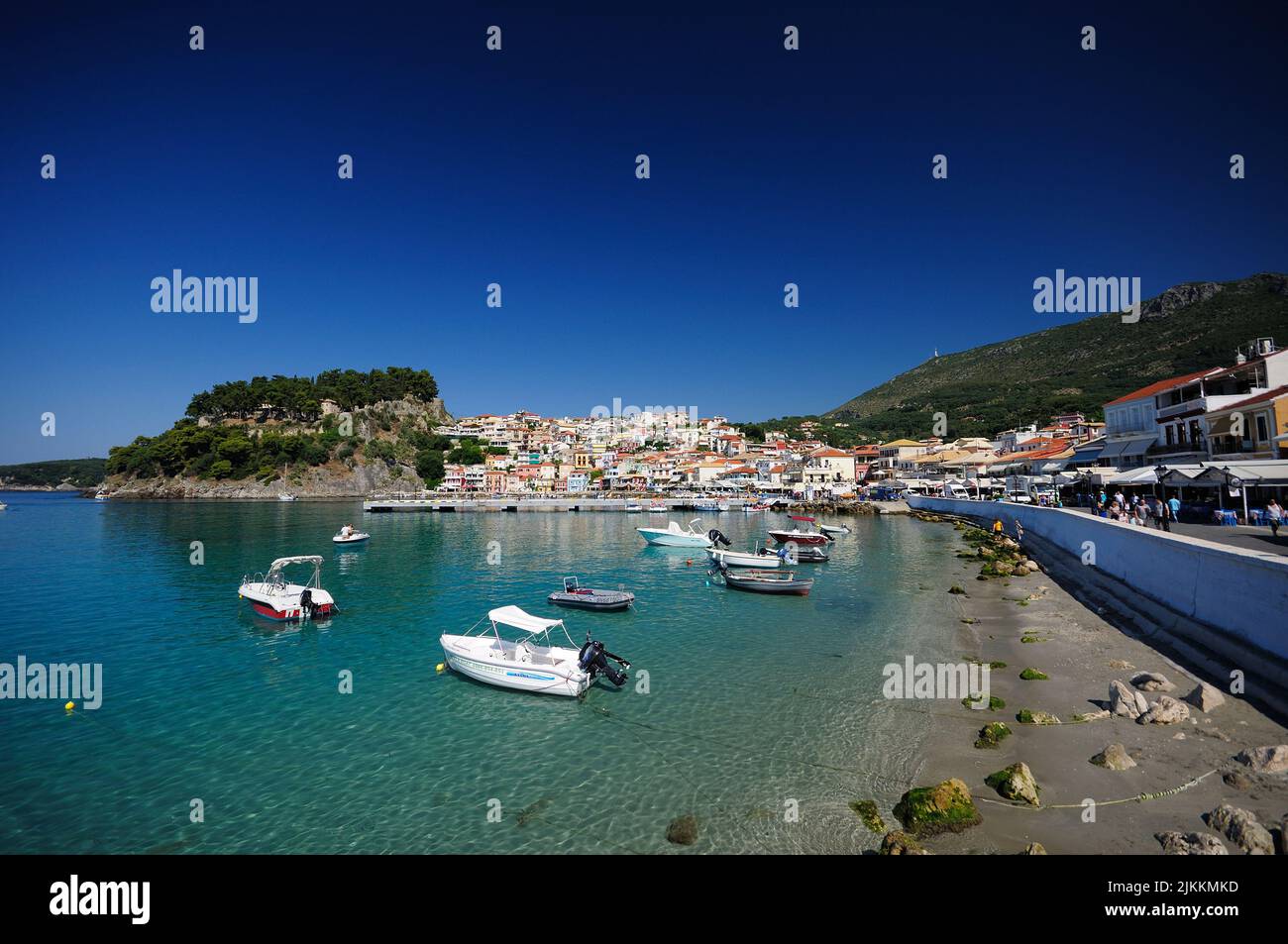 Una vista panoramica delle barche che navigano in mare contro lo spazio cittadino di Parga, Epiro, Grecia in una giornata di sole Foto Stock