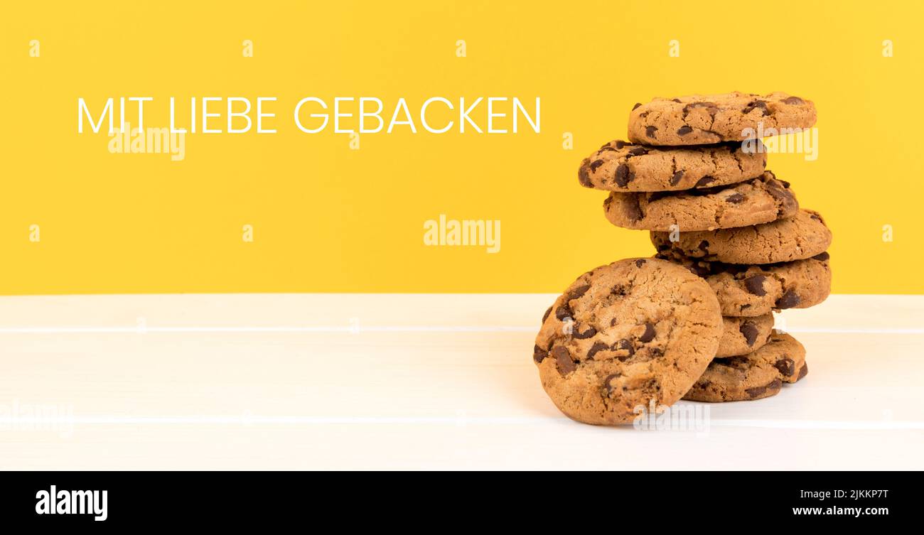 biscotti con sfondo giallo e spazio di copia panorama e tedesco testo mit liebe gebacken, in inglese cotto con amore Foto Stock