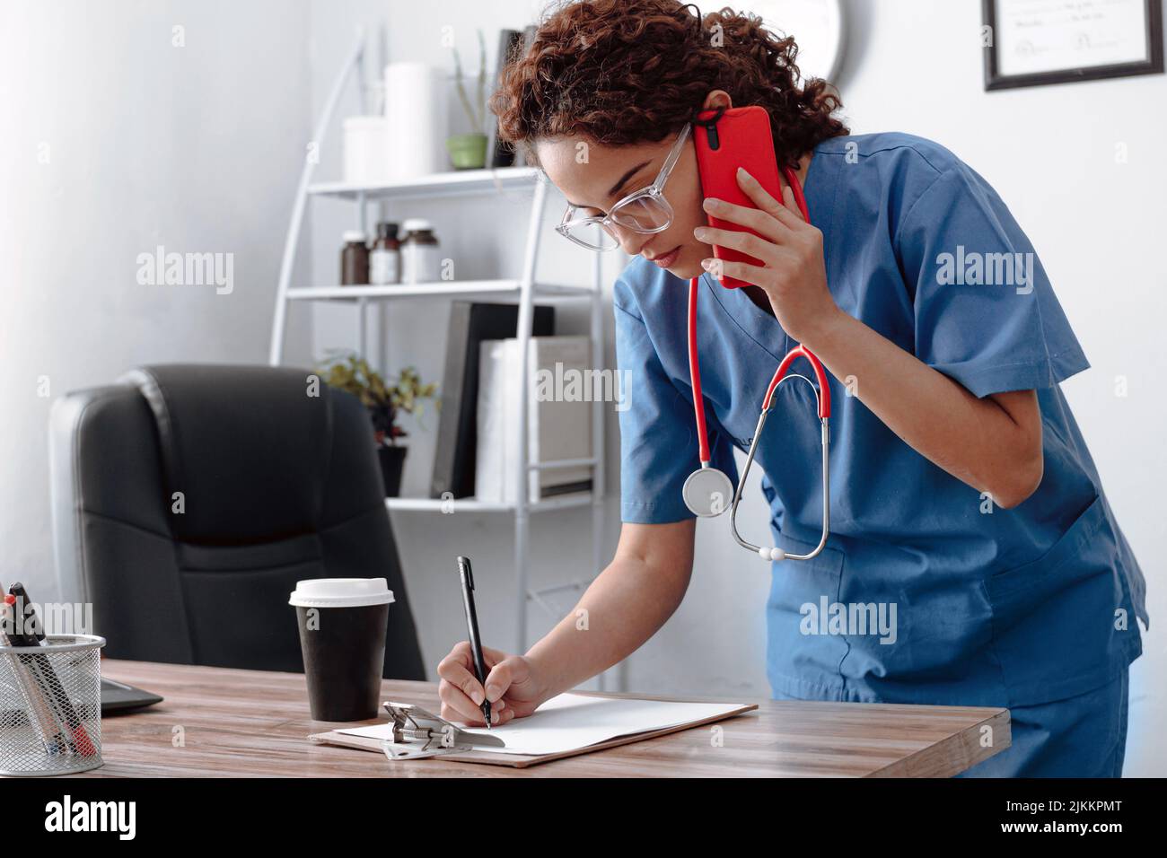 donna medico scrivere con una penna su un pezzo di carta. Foto Stock