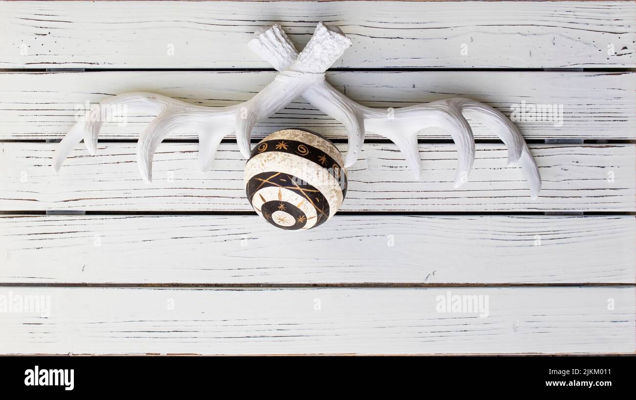 Fieno posare con spazio per il testo - tema di Natale - antler bianco e un ornamento di Natale su sfondo bianco dipinto in legno Foto Stock