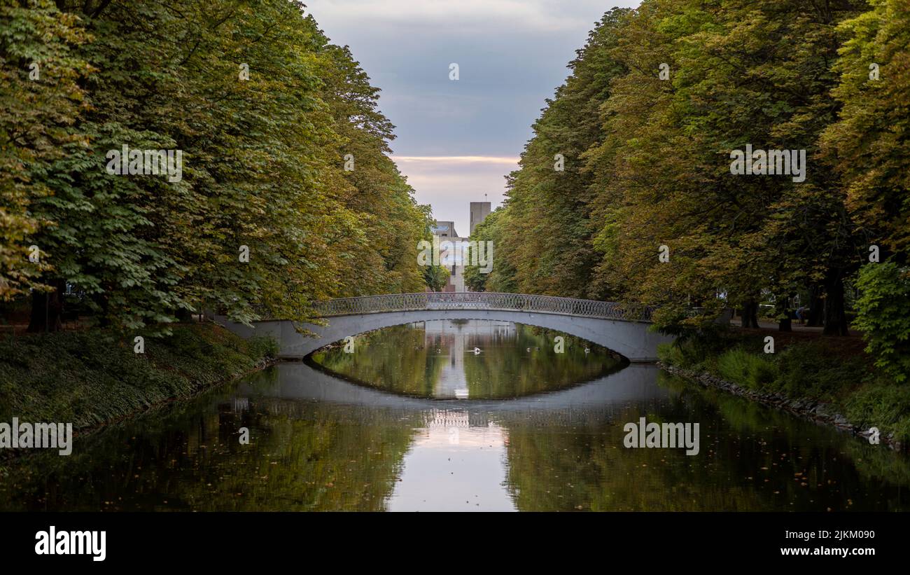 Un ponte ad arco che conduce su un canale navigabile a Colonia in una serata estiva Foto Stock