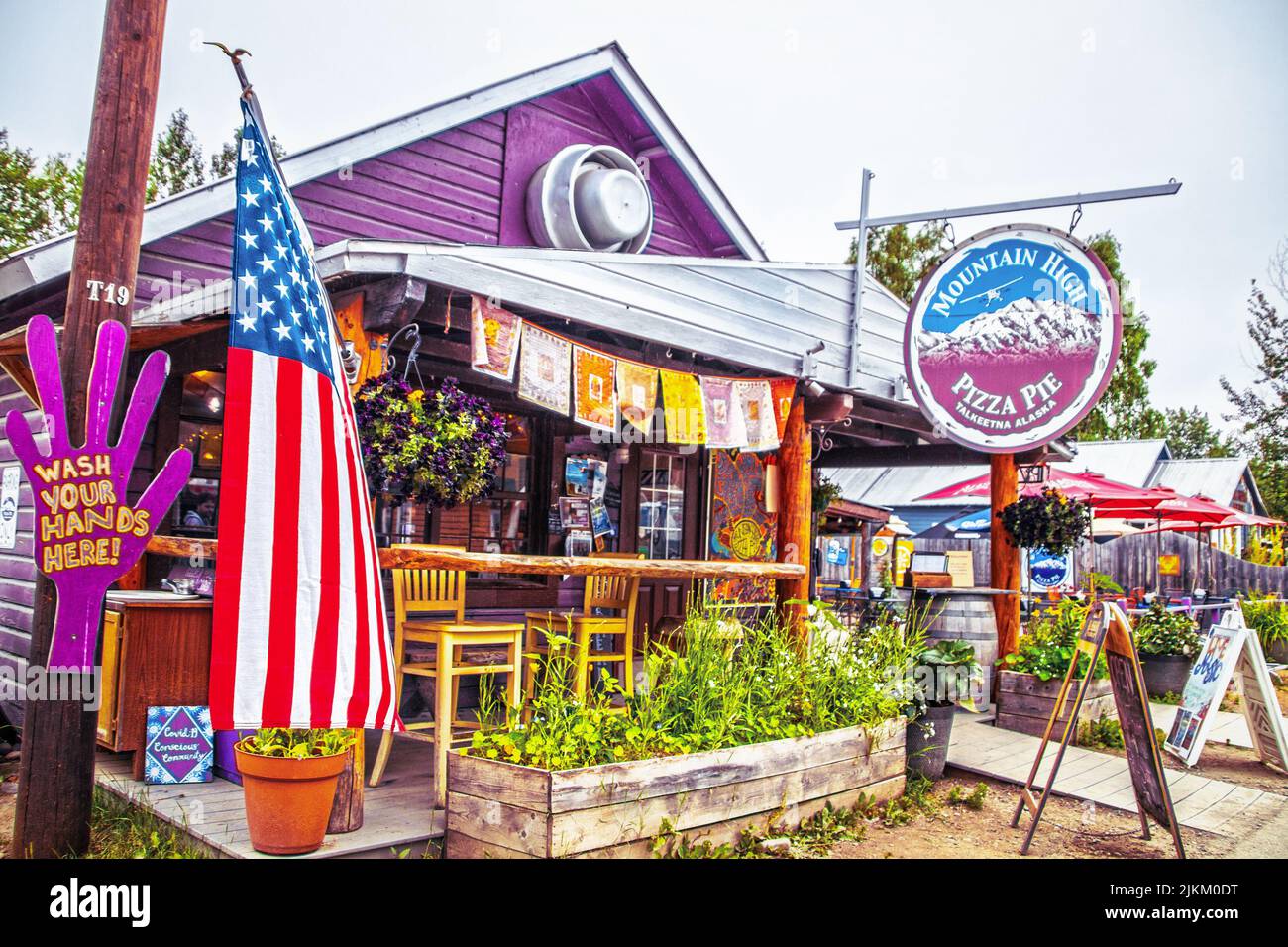 2022 06 26  Talkeetna Alaska USA - Ristorante Mountain High Pizza Pie in cabina con puple siding lavare le mani qui segno e bandiera americana così come Foto Stock