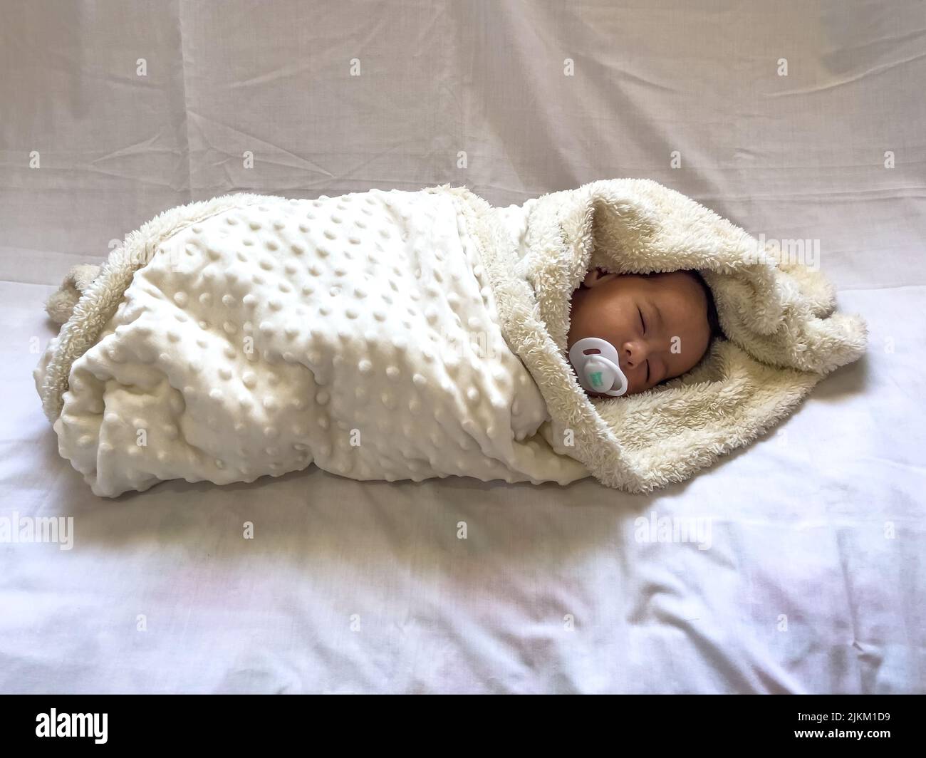 Dolce e tranquillo bambino sdraiato su un lenzuolo bianco godere di sonno di giorno Foto Stock