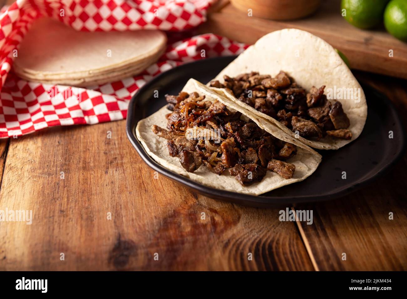 Taco de Bistec. Carne alla griglia fatta in casa in una tortilla di mais. Cibo di strada dal Messico, tradizionalmente accompagnato con coriandolo, cipolla e salsa piccante o. Foto Stock