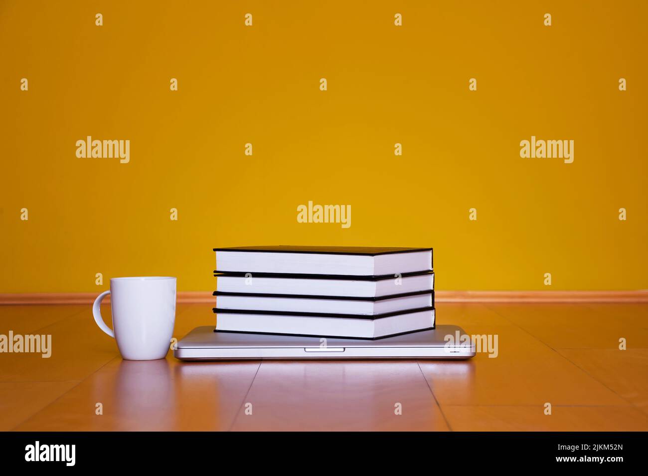 Concetto di ritorno a scuola, computer portatile libri tazza di caffè su pavimento in legno Foto Stock