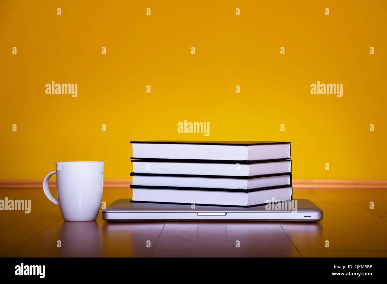 Concetto di ritorno a scuola, computer portatile libri tazza di caffè su pavimento in legno Foto Stock
