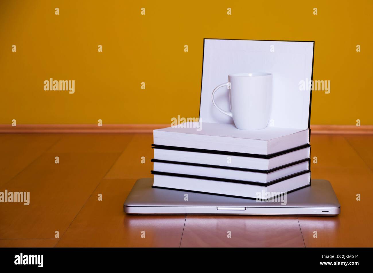 Concetto di ritorno a scuola, computer portatile libri tazza di caffè su pavimento in legno Foto Stock