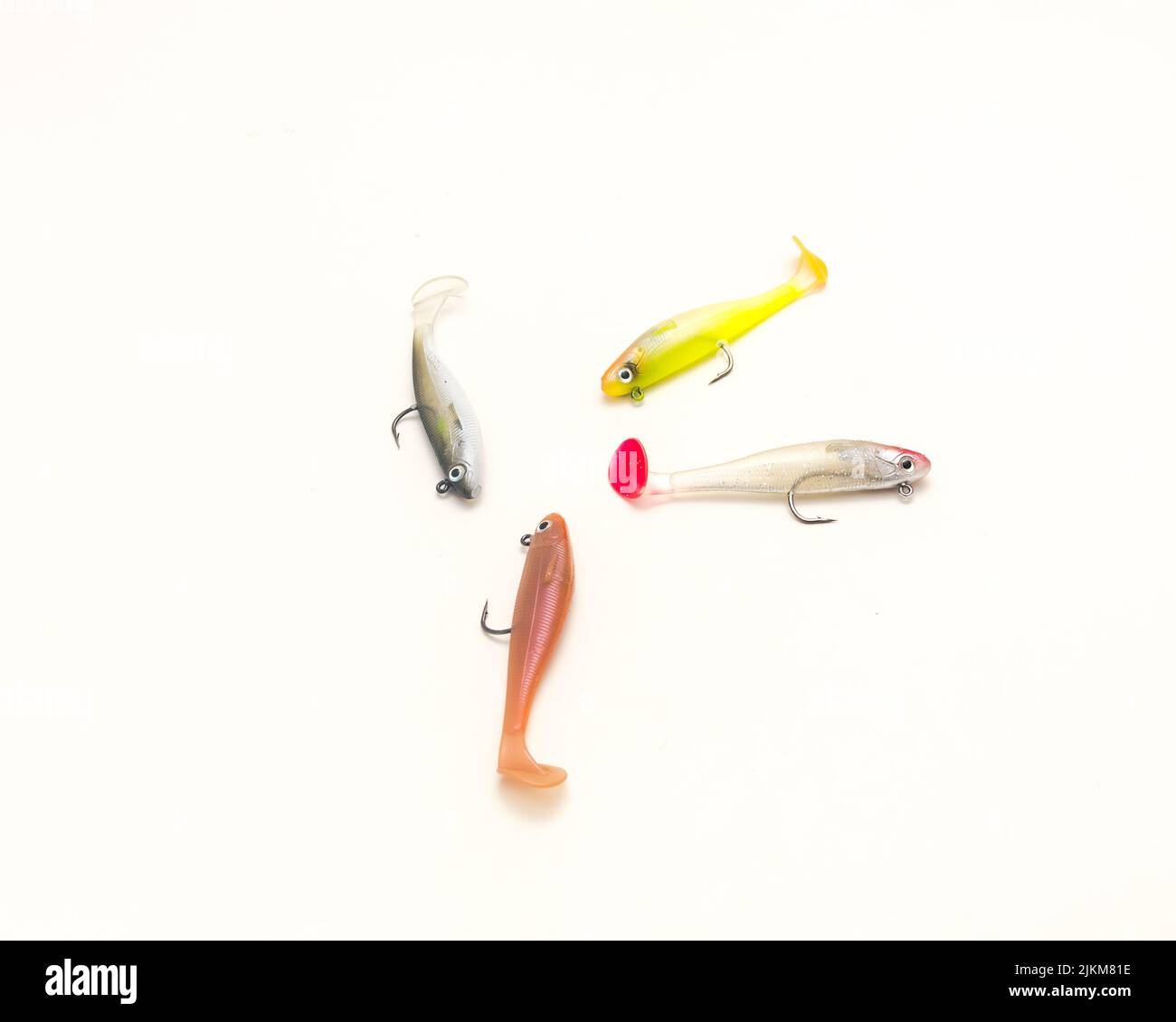 Quattro stoppini testa shad Soft pesca Lures con gancio e coda a paddle Swimbaits isolato su sfondo bianco. Esche artificiali in plastica per bassi a righe, fre Foto Stock